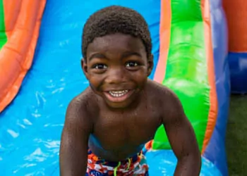 Boy on colorful water slide - Party Rentals in Cumming, GA