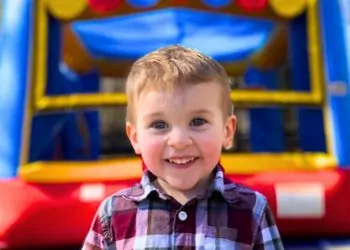 Boy in front of inflatable bounce house